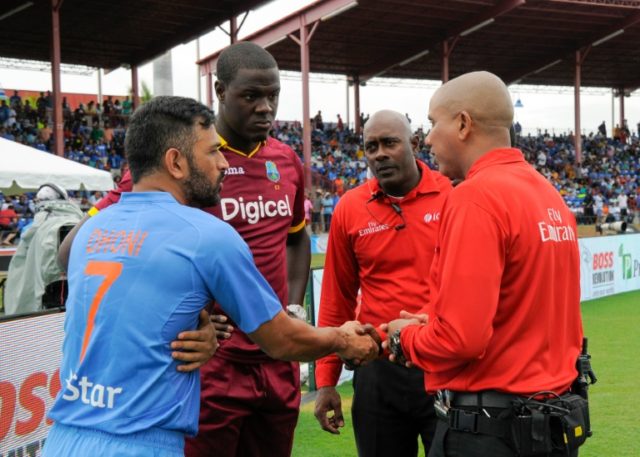 Mahendra Singh Dhoni (L) of India and Carlos Brathwaite (2ndL) of West Indies agree with u