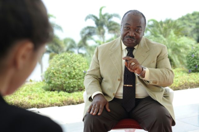 Gabonese President Ali Bongo Ondimba gestures as he speaks to journalists during an interv