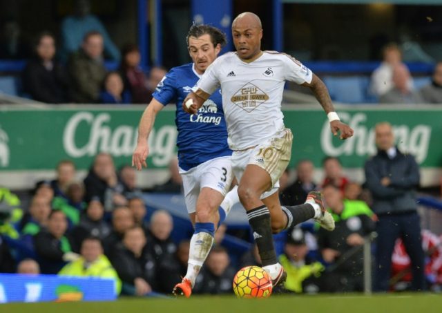 Swansea City's Ghanaian striker Andre Ayew (left) runs with the ball, chased by Everton's