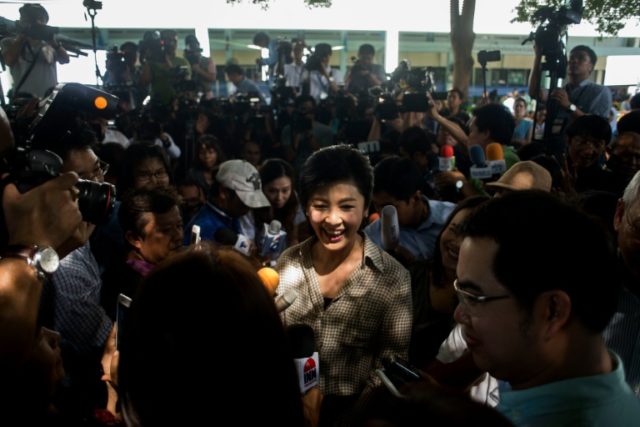 Former Thai prime minister Yingluck Shinawatra talks to the media after casting ballot at