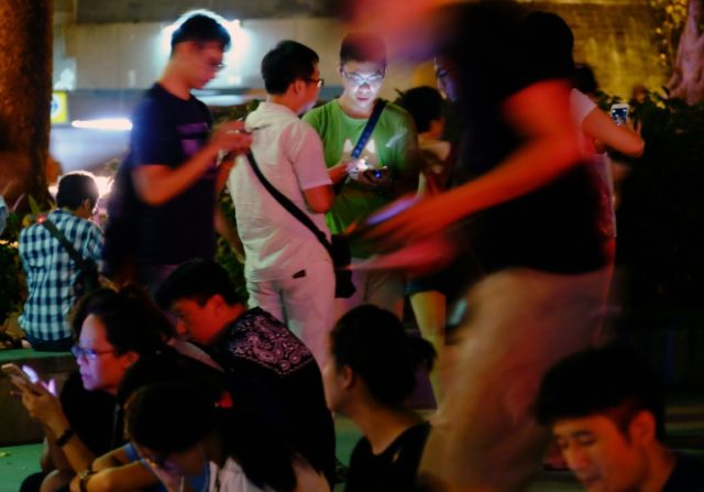 Local gamers play Pokemon Go at the Beitou Park in Taipei on August 23, 2016