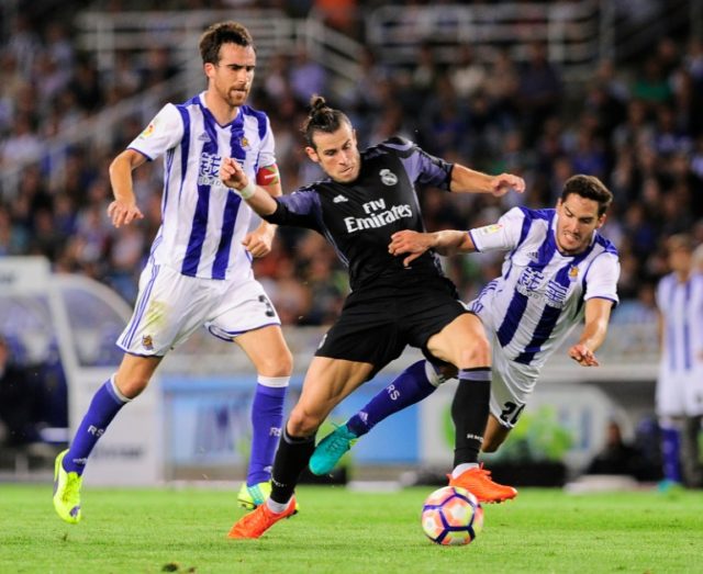 Real Madrid's forward Gareth Bale (C) clashes with Real Sociedad's defender Joseba Zaldua