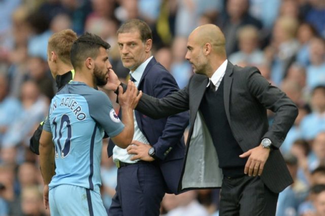 Manchester City's manager Pep Guardiola (R) greets striker Sergio Aguero after he was subs