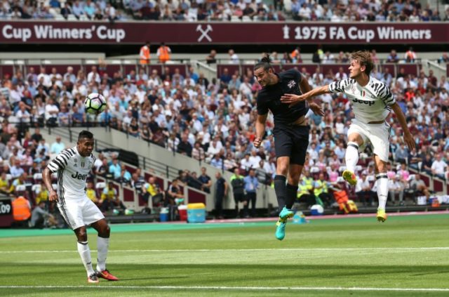 West Ham United's striker Andy Carroll (C) heads the ball to score against Juventus on Aug