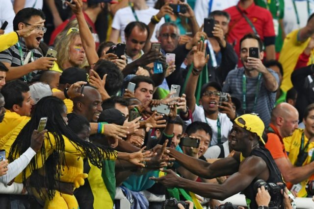 Jamaica's Usain Bolt celebrates with fans after winning the men's 100m final during the at
