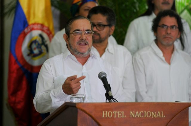 The head of Colombia's FARC rebel force, Timoleon Jimenez, aka "Timochenko" (C), speaks du