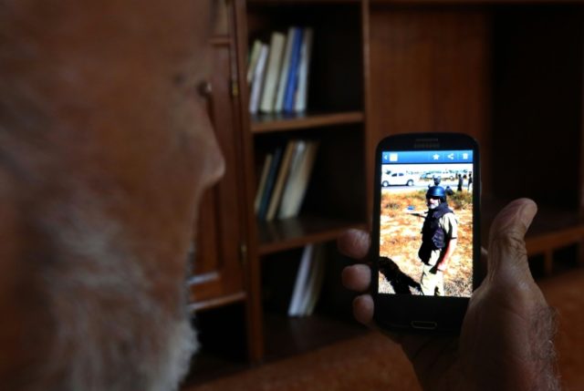 Eshtewi Khalifa shows a picture of his cousin Abdelrahman al-Kissa, who died in June fight