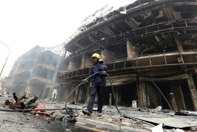 An Iraqi firefighter works at the site of a Baghdad bombing claimed by the Islamic State g