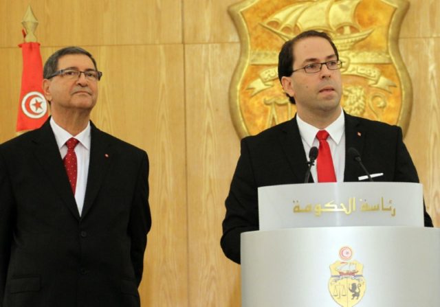 Tunisia's new Prime Minister Youssef Chahed (R) delivers a speech during a handover ceremo