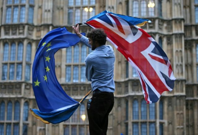 A man waves a British flag and a European flag at an anti-Brexit protest in central London