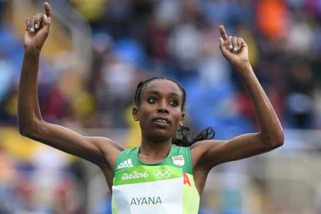 Ethiopia's Almaz Ayana celebrates as she crosses the finish line to win the women's 10,000