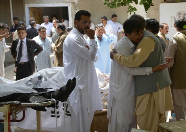 Relatives mourn next to bodies of victims after a bomb explosion at a government hospital