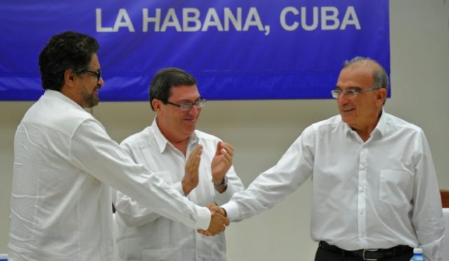 Colombian government delegation head Humberto de la Calle (R) and FARC-EP Commander Ivan M