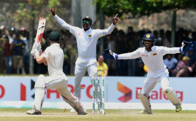 Sri Lanka's captain Angelo Mathews (C) and wicketkeeper Dinesh Chandimal (R) celebrate the