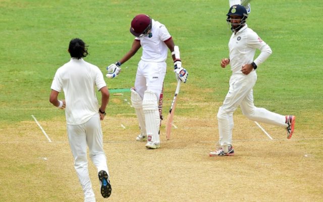 Rajendra Chandrika of the West Indies reacts after being bowled out by Ishant Sharma (L) o