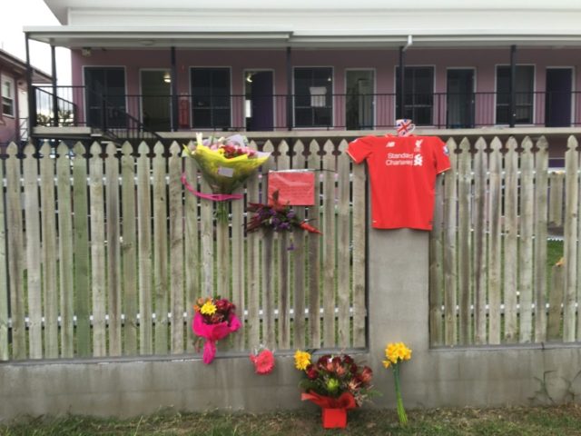 Flowers and messages are placed on a fence outside the hostel where British backpacker Mia