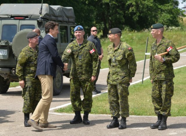 Canadian Prime Minister Justin Trudeau (2nd left) shakes hands with Canadian military inst