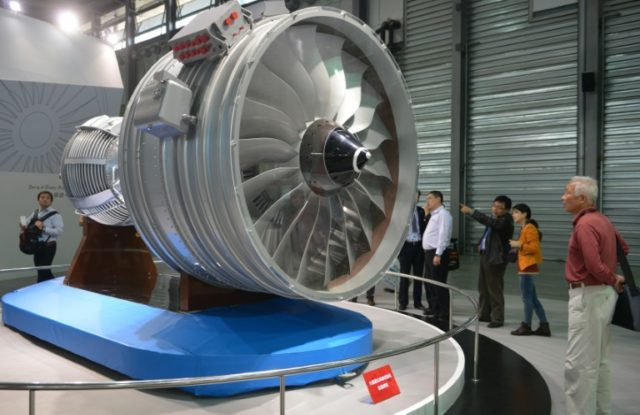 Visitors look at a full-size model of an aircraft jet engine made by China Aviation Indust