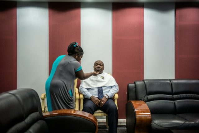 Gabon President Ali Bongo sits for make up ahead of a televised electoral debate in Librev
