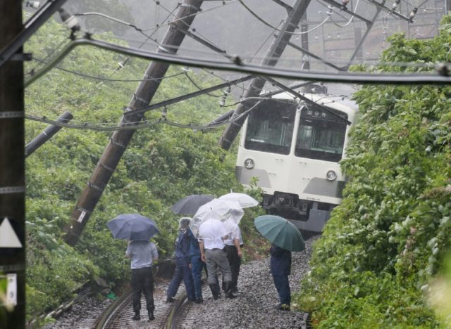 A train derailed by a landslide is seen on the Seibu Tamako line in Higashimurayama, weste