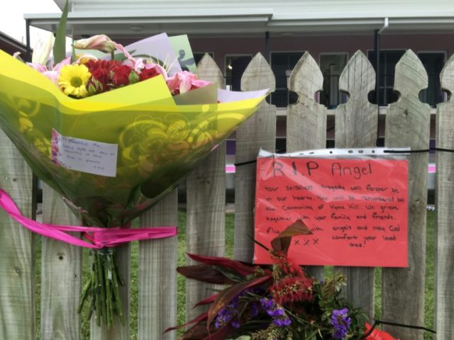 Flowers and messages are placed on a fence outside the hostel where British backpacker Mia