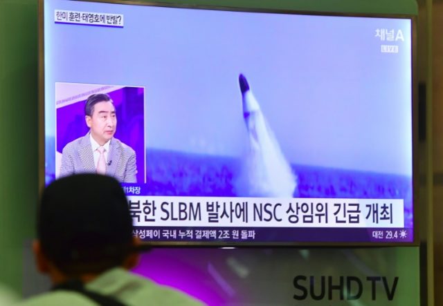 A man watches television news showing footage of a North Korean missile launch on August 2