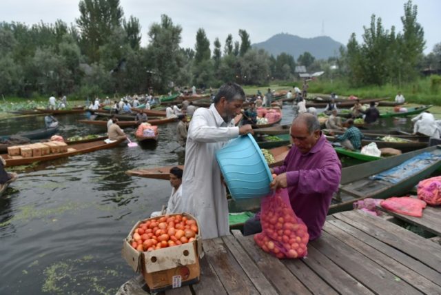 Kashmiri Muslims gather with their boats laden with fruits and vegetables, at the floating