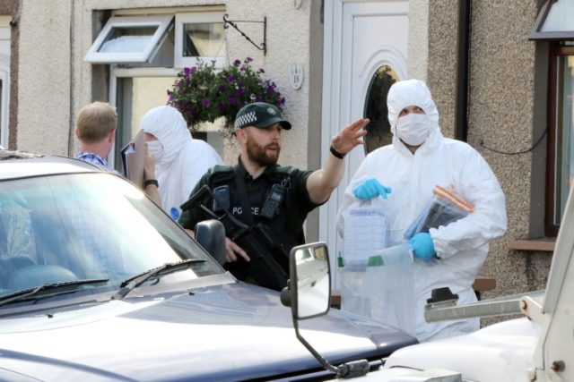 Police forensic officers carry evidence on August 24, 2016, in one the searches at address
