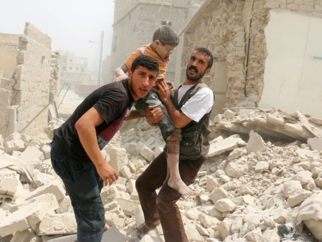 Syrians carry a wounded child in the rubble of buildings following a barrel bomb attack on the Bab al-Nairab neighbourhood of the northern Syrian city of Aleppo on August 25, 2016