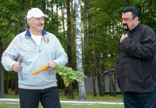 Belarus president Alexander Lukashenko peels a carrot before handing it to US action star