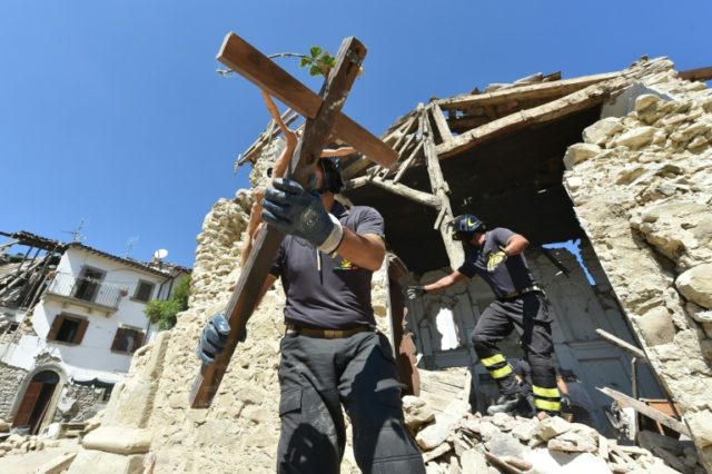 Firefighters recover a crucifix from a damaged church in Rio, one of the villages affected
