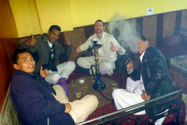 Irish tourist Jonny Blair (C-R) drinks tea and smokes shisha with three Afghan companions