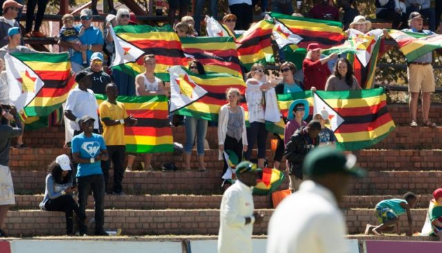 Zimbabwe cricket supporters sing the national anthem on the first day of the second Test a