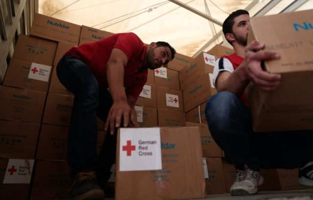 The Syrian Arab Red Crescent delivers aid boxes to the besieged rebel bastion of Douma on