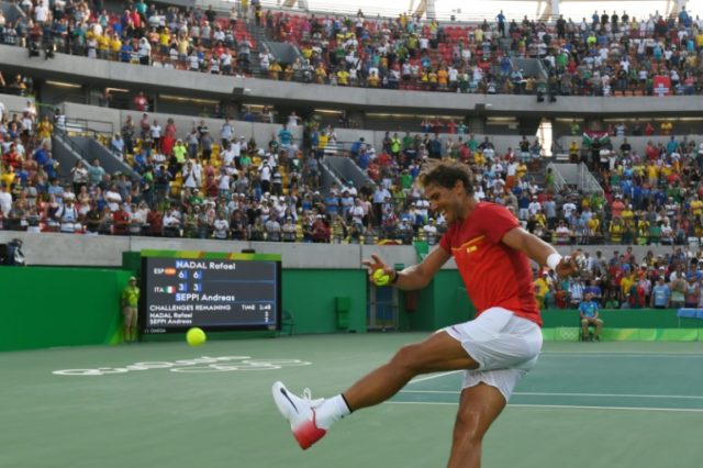 Rafa Nadal kicks a signed tennis ball into the crowd in Rio on August 9, 2016