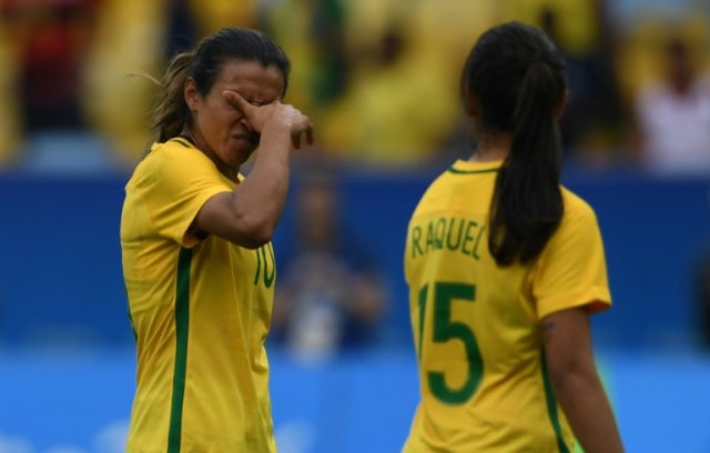 Brazil players Marta (left) and Raquel Fernandes leave the field in dejection after losing