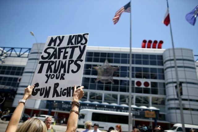 A protestor holds a sign during a demonstration in favor of gun regulation outside of the