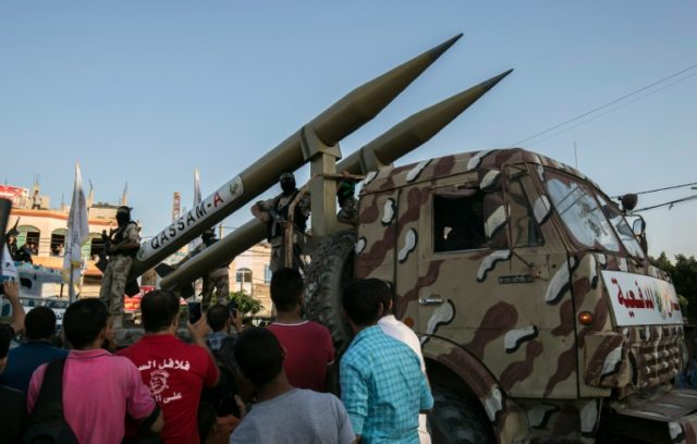 Palestinian members of the al-Qassam Brigades, the armed wing of the Hamas movement, display home-made rockets during an anti-Israel parade in Rafah in the southern Gaza Strip