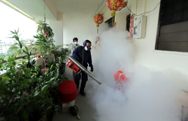 Workers are seen fogging a housing estate in Singapore on August 28, 2016 after authoritie