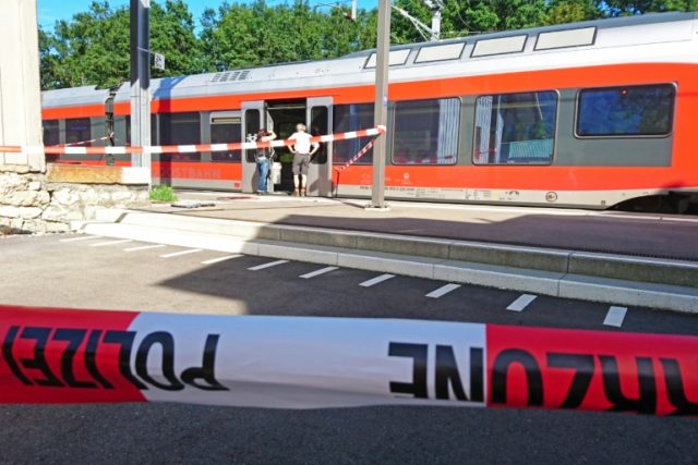 Policemen stand by a train at the station in Salez, eastern Switzerland, after a man set a