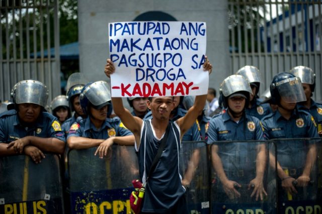 An activist hold a banner in front of the Philippine National Police headquarters during a