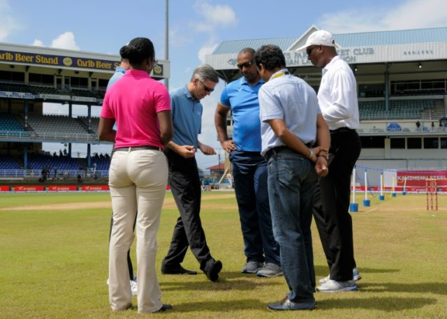 Umpire Nigel Llong (2ndL) illustrates a point to West Indies head coach Phil Simmons (3rdL
