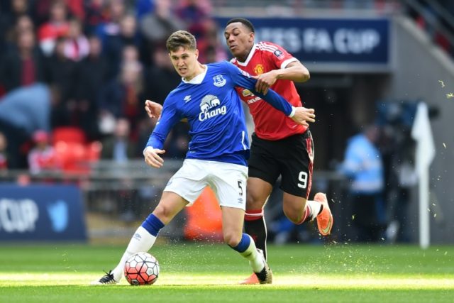 Everton defender John Stones (L) is challenged by Manchester United striker Anthony Martia