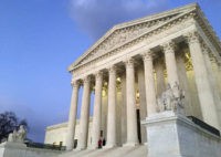 People stand on the steps of the Supreme Court at sunset in Washington. AP Photo