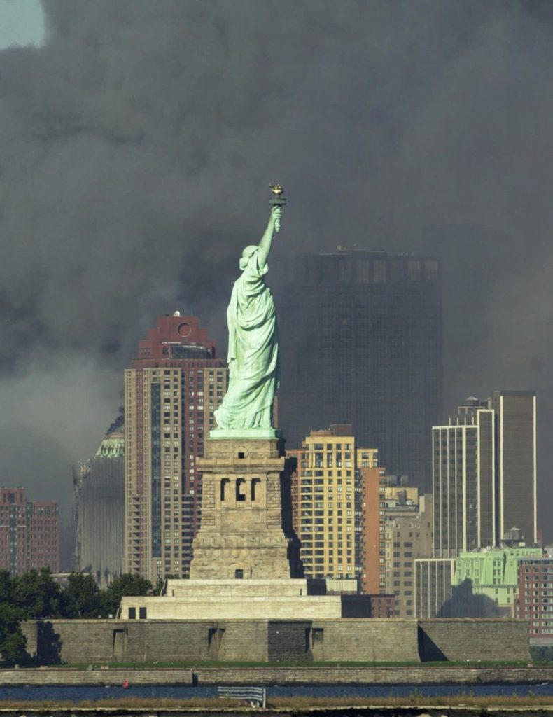 Thick smoke billows into the sky from the area behind the Statue of Liberty where the World Trade Center towers stood Tuesday, Sept. 11, 2001. The towers collapsed after terrorists crashed two planes into them Tuesday. (AP Photo/Daniel Hulshizer)