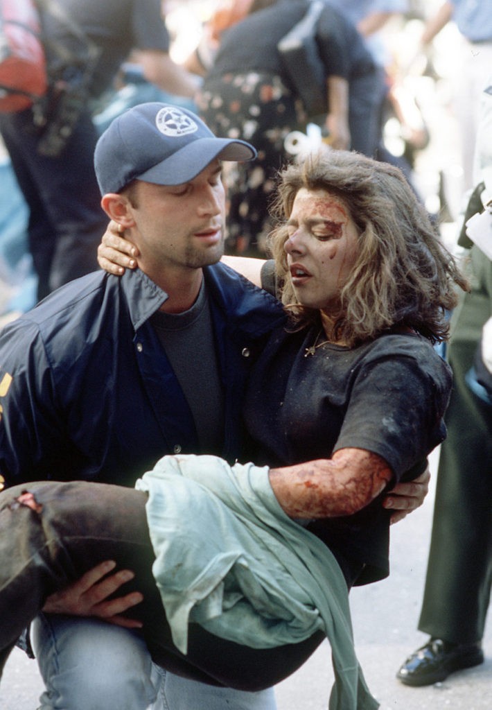 Deputy U.S. marshal Dominic Guadagnoli helps a women after she was injured in the terrorist attack on the World Trade Center in New York, Tuesday, Sept. 11, 2001. (AP Photo/Gulnara Samoilova)