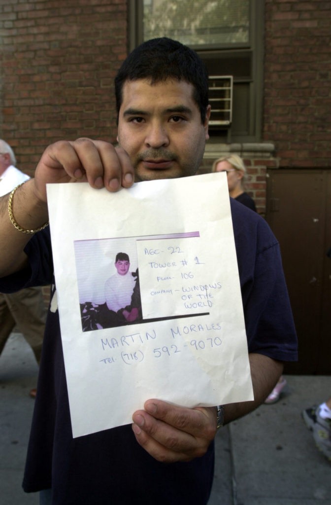 In this September 13, 2001 photograph, a man poses with a picture of a missing loved one who was last seen at the World Trade Center when it was attacked on September 11, 2001.(AP Photo/Kathy Willens)