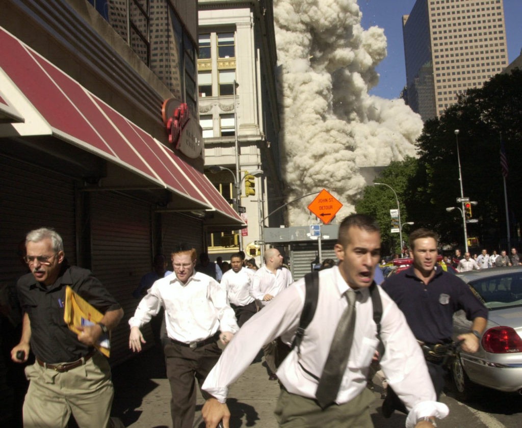 People run from the collapse of one of the twin towers of New York's World Trade Center in this Sept. 11, 2001, file photo. (AP Photo/FILE/Suzanne Plunkett)