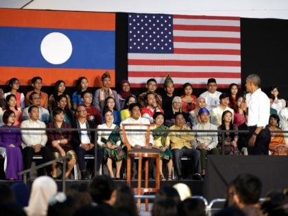 President Barack Obama looks to audience members seating behind him on stage as he speaks