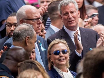 Democratic presidential candidate Hillary Clinton, center, accompanied by Sen. Chuck Schumer, D-N.Y., center left, Rep. Joseph Crowley, D-N.Y., second from left, and New York Mayor Bill de Blasio, center top, attends a ceremony at the Sept. 11 memorial, in New York, Sunday, Sept. 11, 2016. (AP Photo/Andrew Harnik)